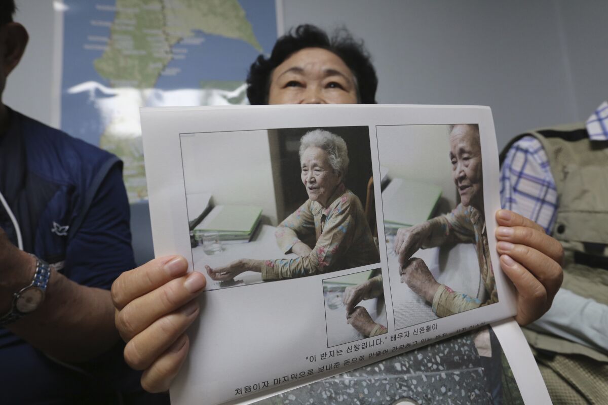South Korean Shin Yun-sun shows photos of her 92-year-old mother, Baek Bong-rye, during an interview at her house in Seoul, South Korea Wednesday, July 29, 2020. Shin, 75, has spent decades pestering government officials, digging into records and searching burial grounds on Russia’s desolate Sakhalin island, desperately searching for traces of a father she never met. Shin wants to bring back the remains of her presumably dead father for her ailing mother. Japan's colonial government conscripted Shin's father for forced labor from their farming village in September 1943, when Baek was pregnant with Shin.(AP Photo/Ahn Young-joon)