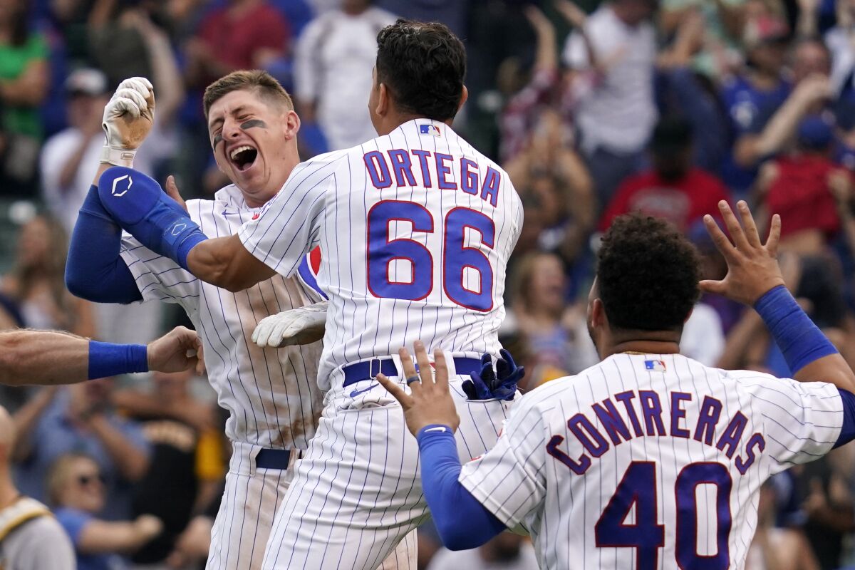 Chicago Cubs' Frank Schwindel, left, celebrates with Rafael Ortega, center, and Willson Contreras after hitting the game-winning single against the Pittsburgh Pirates in the ninth inning of a baseball game in Chicago, Saturday, Sept. 4, 2021. The Cubs won 7-6. (AP Photo/Nam Y. Huh)