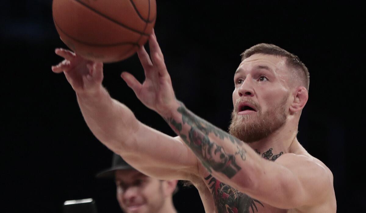 Conor McGregor shoots a basketball on the floor of Madison Square Garden during an open workout on Wednesday.