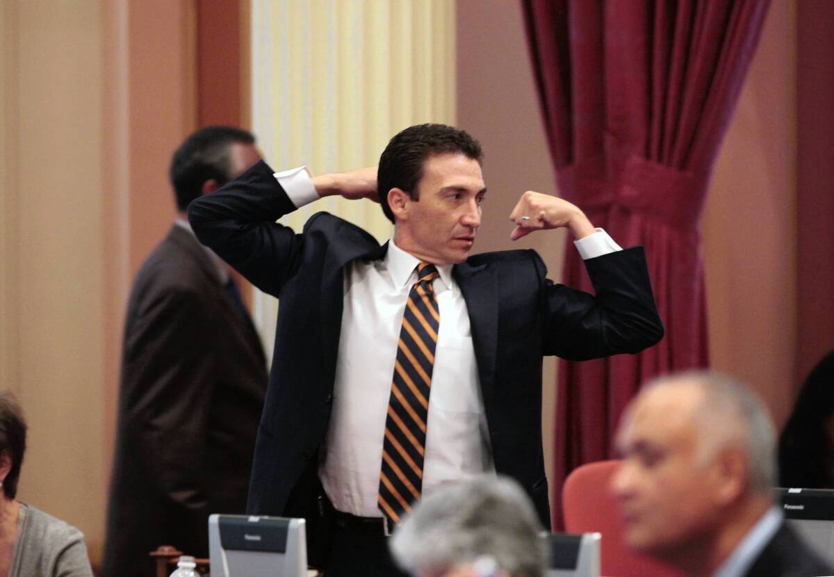 State Sen. Michael Rubio (D-East Bakersfield) stretches during a lull in Thursday's legislative deliberations in Sacramento. The lawmakers are facing a midnight Friday deadline to adjourn their two-year session.
