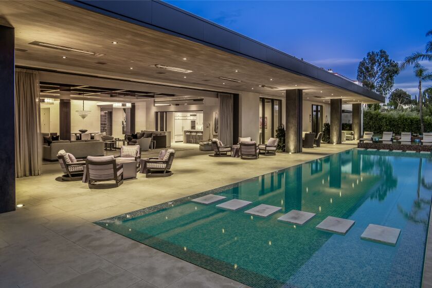 The fully furnished mansion spans 13,000 square feet with six bedrooms, 11 bathrooms, motorized walls of glass and an infinity pool out back.