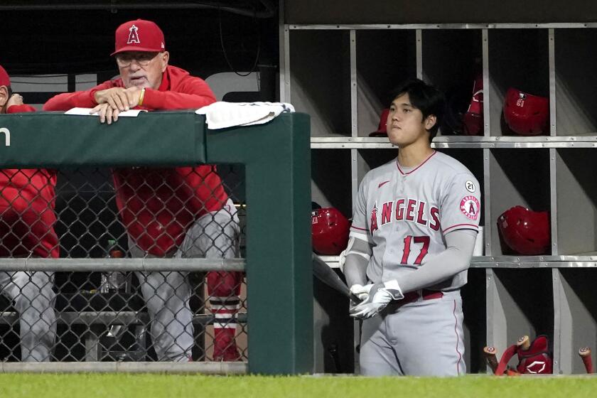 Los Angeles Angels manager Joe Maddon, left, and designated hitter Shohei Ohtani watch from the dugout during the fourth inning of the team's baseball game against the Chicago White Sox on Wednesday, Sept. 15, 2021, in Chicago. (AP Photo/Charles Rex Arbogast)