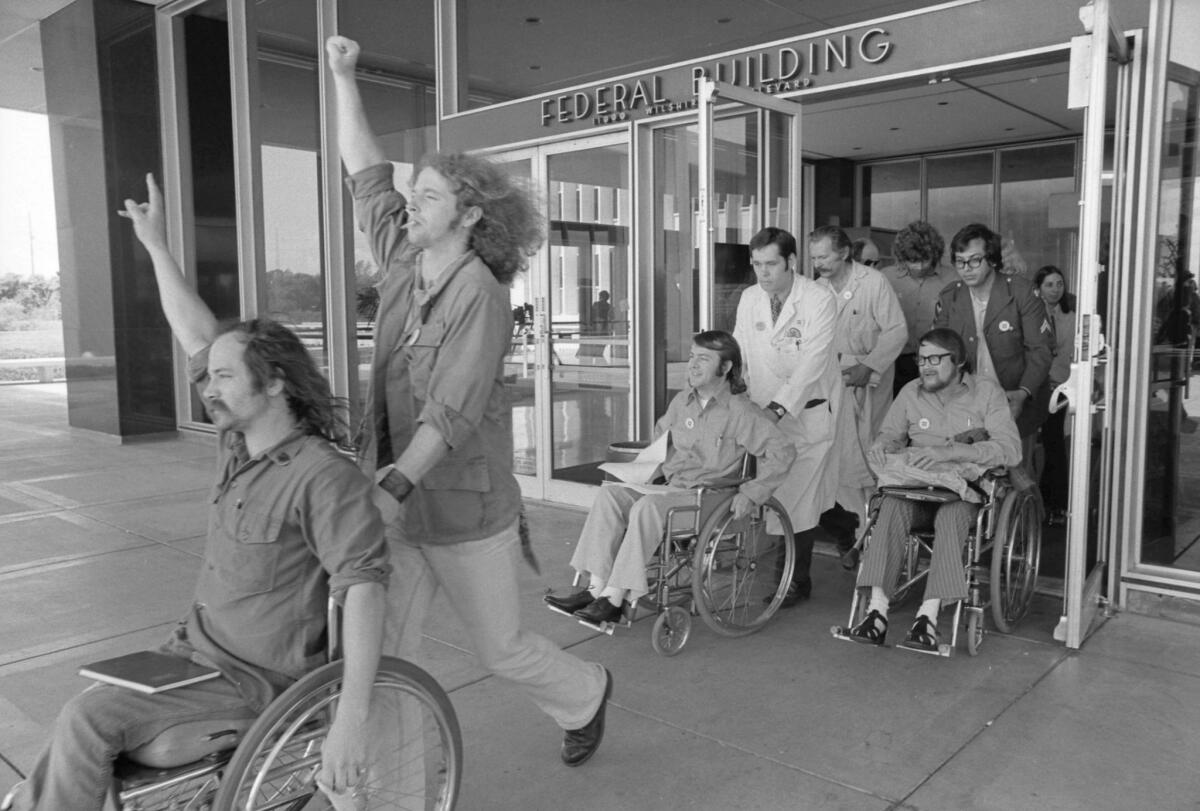 Ron Kovic, left, leads disabled veterans from the Wilshire Boulevard federal building afer ending a 17 day hunger strike.