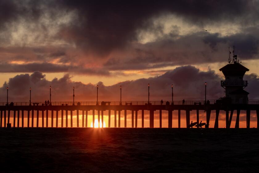 Huntington Beach, CA - February 27: With a break in the rain, surfers are silhouetted by a dramatic sunset and cloudy skies after new winter storms brought more precipitation to Southern California Monday and will continue through Wednesday, after last week's epic storms dumped record-breaking rainfall and brought historic snow to the Southland. Photo taken in on Monday, Feb. 27, 2023 in Huntington Beach, CA. (Allen J. Schaben / Los Angeles Times)