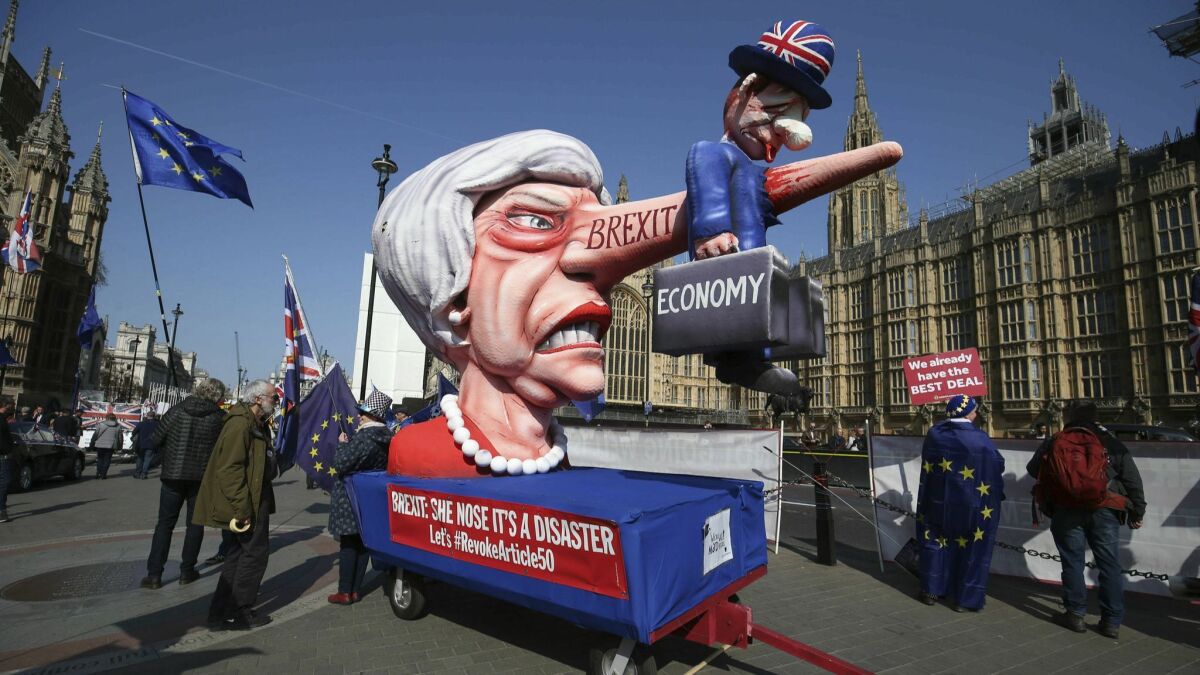 Anti-Brexit demonstrators with an effigy of British Prime Minister Theresa May near College Green at the Houses of Parliament in London on April 1, 2019.