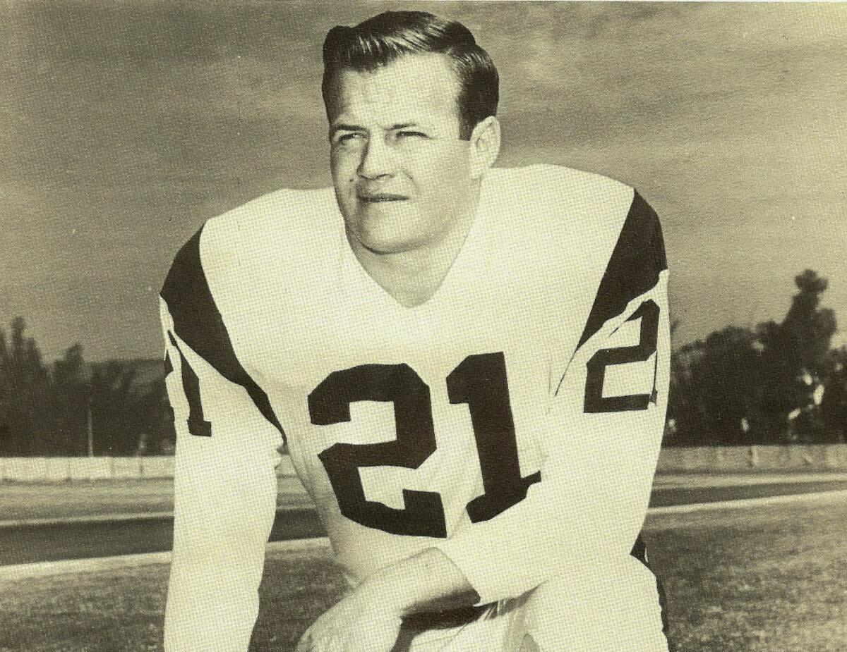 Eddie Meador poses for a photo on a playing field with his helmet off.