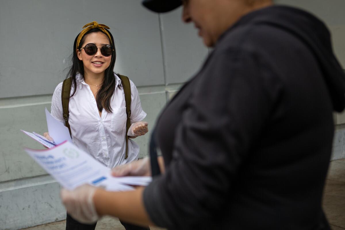  Cristin Lim hands out flyers in Mar Vista offering help to people during the coronavirus pandemic.