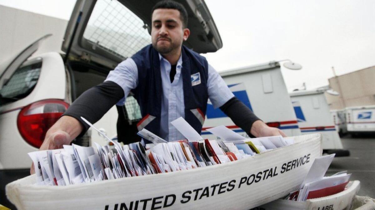 The state Employment Development Department said it will begin working on plans to remove highly sensitive information from most of the forms sent to customers' homes. Above, a letter carrier in 2011.