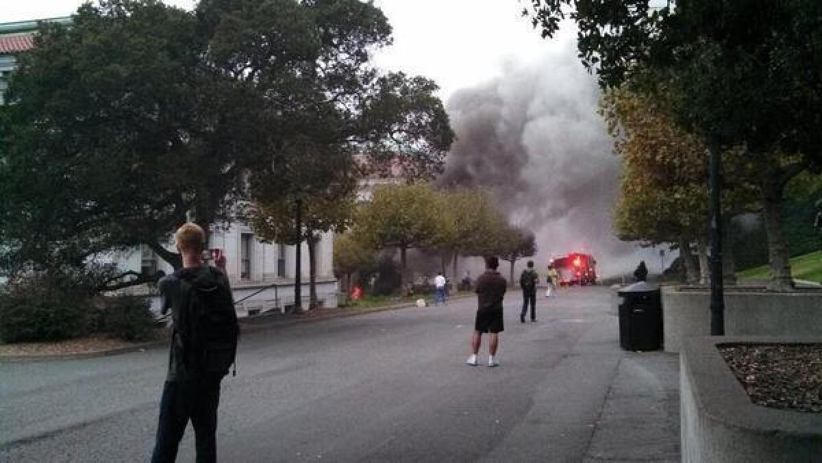 Students stop to look at smoke billowing from an explosion on the UC Berkeley campus Monday. Power was restored to most of the college by early Tuesday.