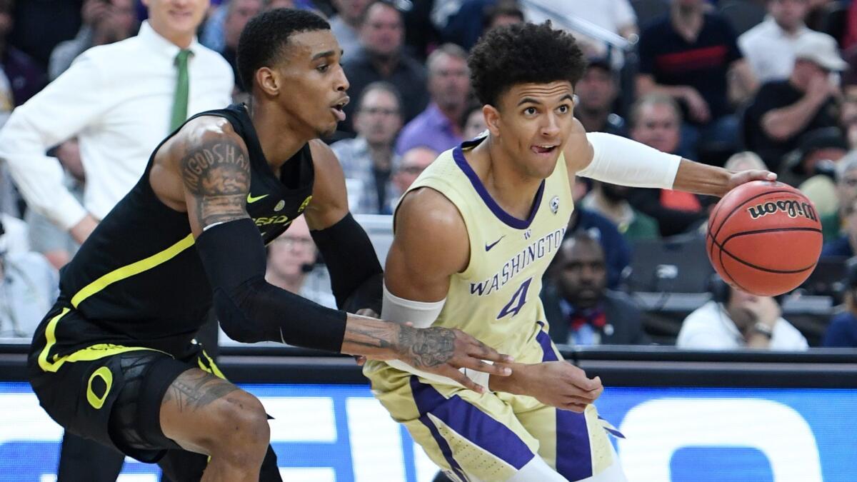Washington's Matisse Thybulle, right, drives against Oregon's Kenny Wooten during the championship game of the Pac-12 basketball tournament at T-Mobile Arena on Saturday in Las Vegas.