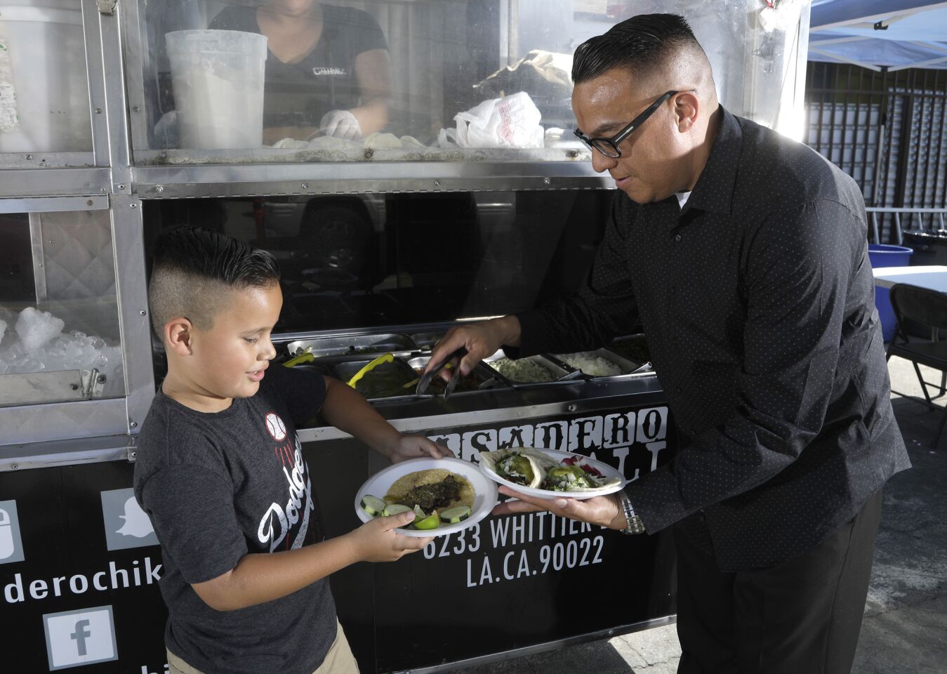 Rudy Valle and son Jordan Ventura, 7, are regulars at the family-owned taco truck, Asadero Chikali, in East Los Angeles. They come two or three times a week. Today was a quick taco lunch before going to a birthday party later.