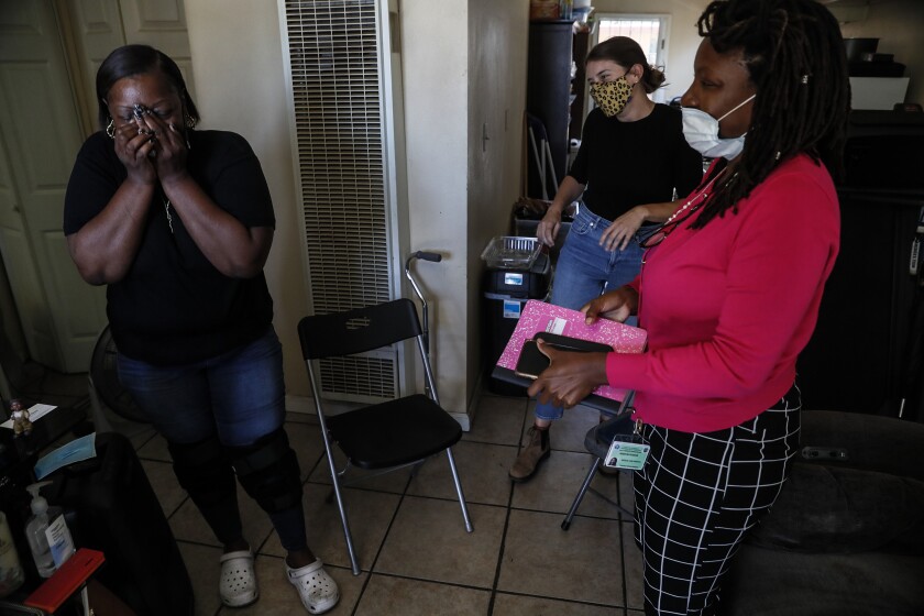 Woman wipes tears from her eyes after visiting with workers.