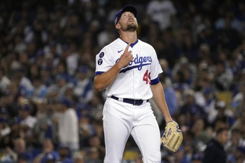 Los Angeles Dodgers relief pitcher Blake Treinen points skyward during the eighth inning