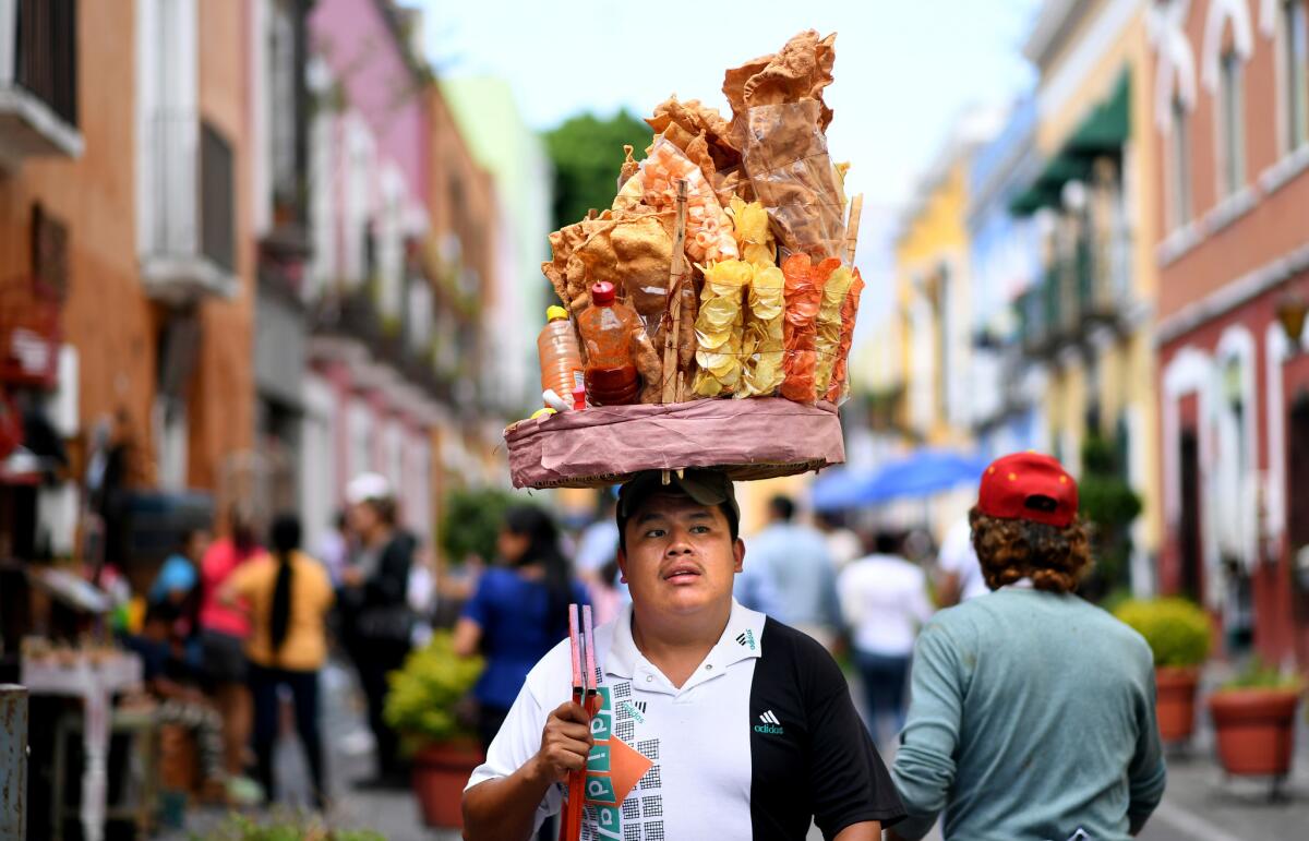A vendor walks along the Alley of the Frogs in Puebla, Mexico.