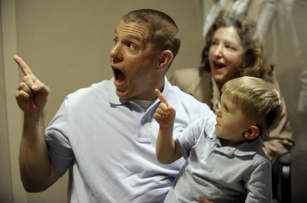 Len Clamp of Charlotte, N.C., reacts with his son Grayson, 3, to hearing and seeing an electronic stuffed animal. Three researchers who were instrumental in developing cochlear implants that could help the profoundly deaf have received the 2013 Lasker Award for clinical research.