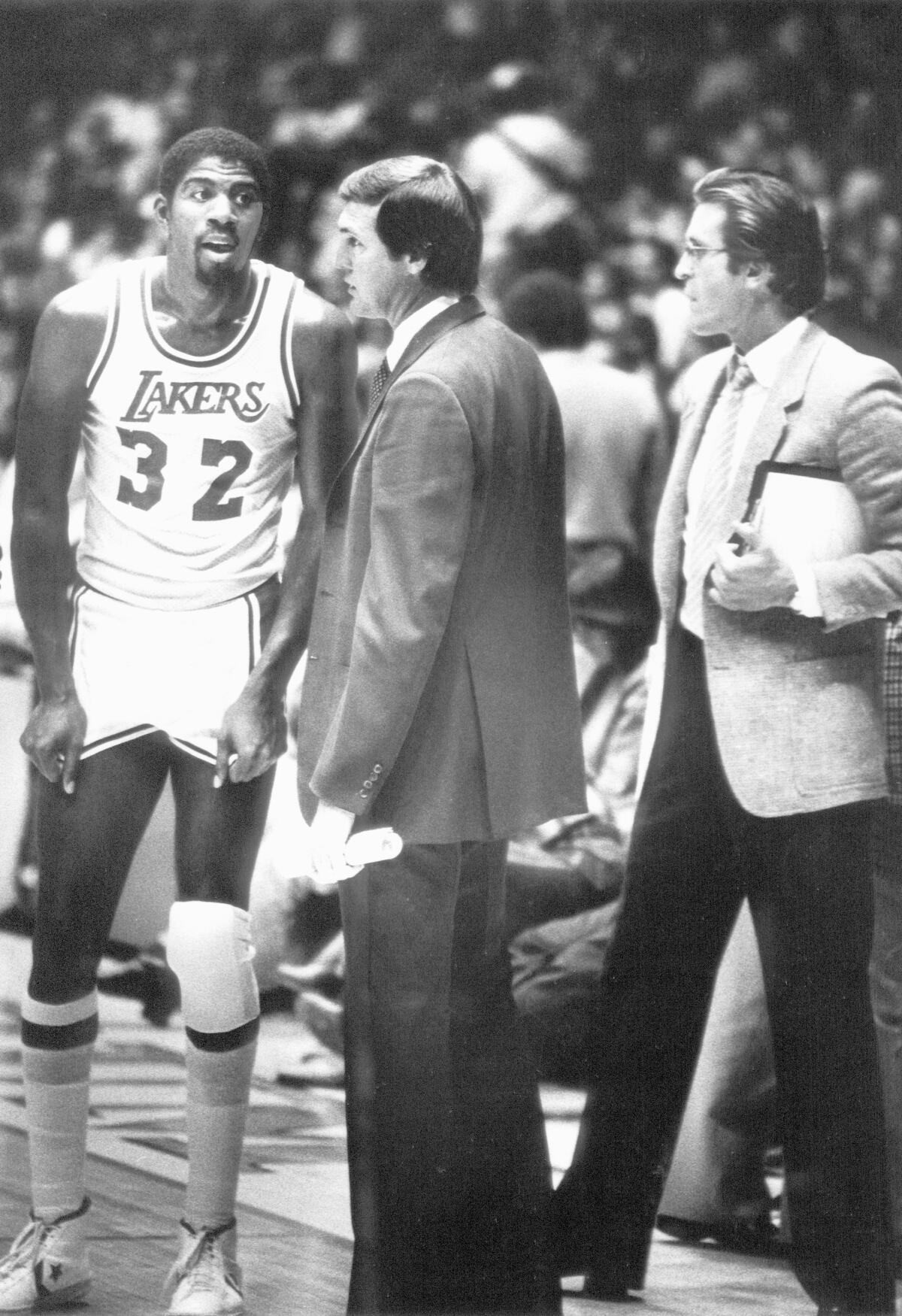 Magic Johnson, left, talks to coaches Jerry West and Pat Riley during a game in 1981.