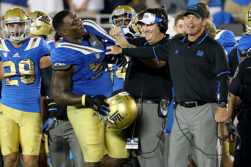 UCLA Coach Jim Mora, right, shares a light moment with defensive lineman Kenny Clark after the Bruins' 24-23 victory over BYU earlier this season.