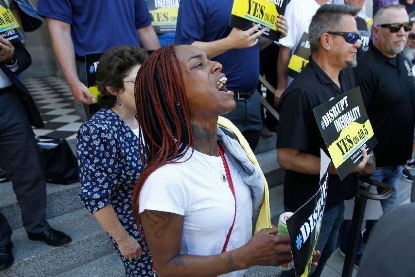 Erica Murphy, a member of Iron Workers Union 378, joins other union members and supporters of a bill to limit when companies can label workers as independent contractors, at a rally in Sacramento, Calif., Wednesday, July 10, 2019. The measure, AB5 by Assemblywoman Lorena Gonzalez, D-San Diego, aimed at major employers like Uber and Lyft, was approved by a Senate committee, Wednesday, and still needs approval by the full Senate. (AP Photo/Rich Pedroncelli)
