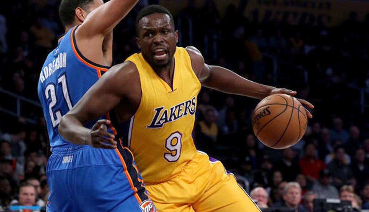 Lakers forward Luol Deng works to the basket against Oklahoma City Thunder forward Andre Roberson in the first quarter Tuesday at Staples Center.