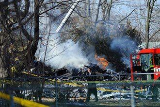 An investigator walks through the scene of a Continental Airlines crash in a suburban area near Buffalo, New York.