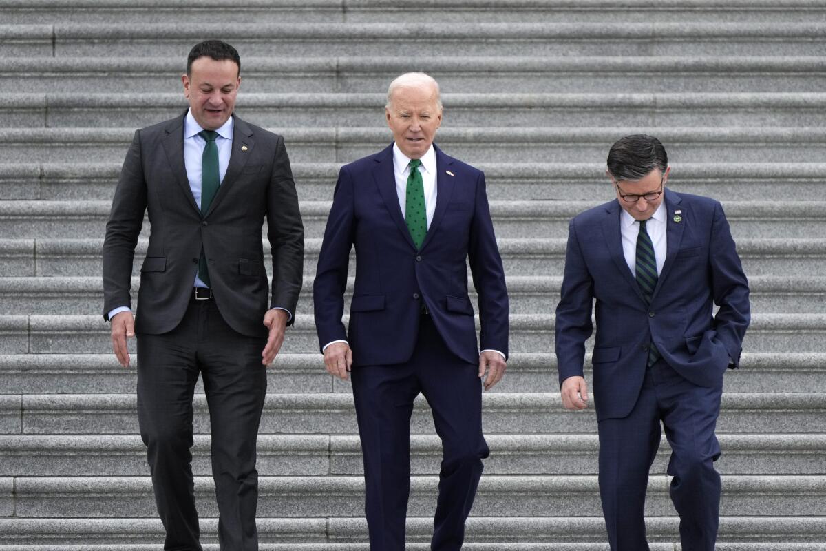 Irish Prime Minister Leo Varadkar, President Biden and Speaker of the House Mike Johnson walk down steps.