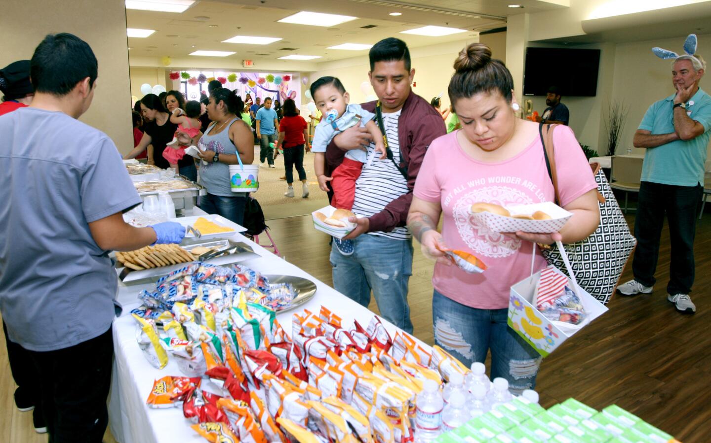 Former patient Iquer Ariel Valeriano and his parents Jose Luis Valeriano, holding him, and Beatriz Lopez, grab lunch at the Dignity Health Glendale Memorial Hospital and Health Center's Neonatal Intensive Care Unit graduate reunion, at the hospital in Glendale on Saturday, April 15, 2017. About 250 former patients and their families attended the event.