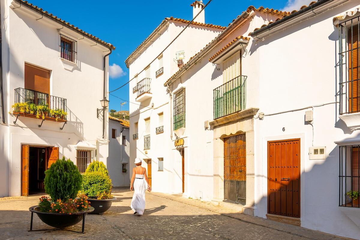 A woman wandering in Cadiz, Spain within whitewashed buildings