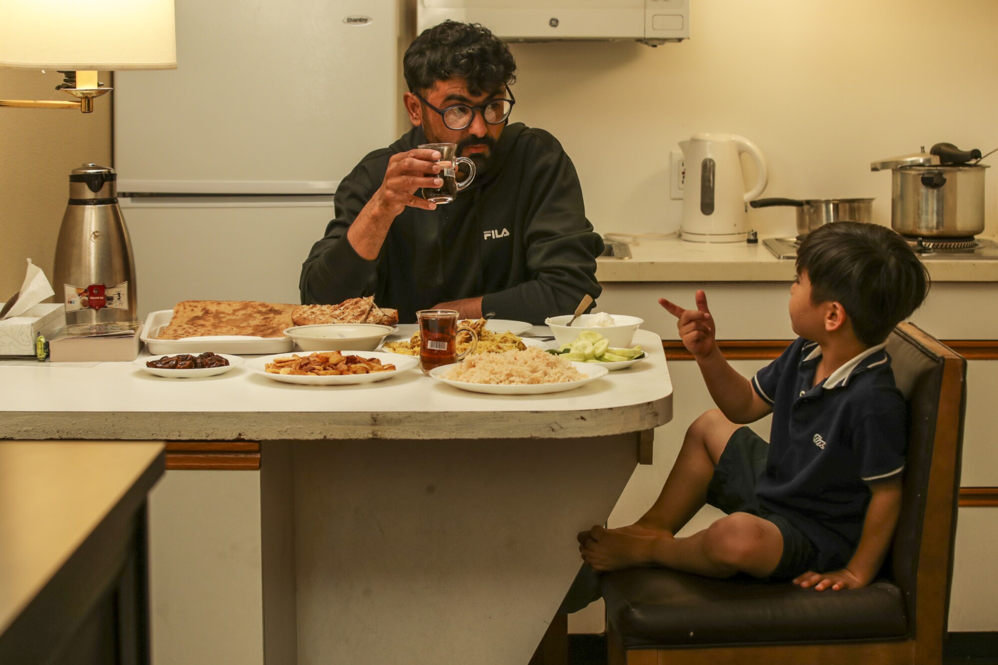 Zabih Khan, left, and his brother Mojib have dinner in their hotel room.