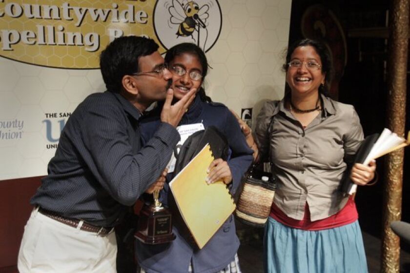 The 42nd annual San Diego Union-Tribune Countywide Spelling Bee was held Tuesday at the Old Town Theater. The eventual winner, Snigdha Nandipati, center, got a kiss from her father Krishnarao Nandipati, left, while her mother Madhavi Nandipati smiles beside her..