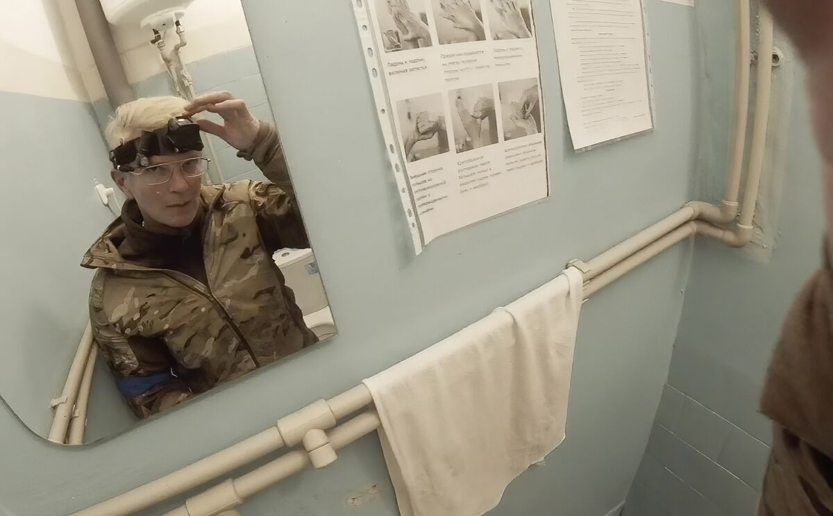 Yuliia Paievska, known as Taira, looks in the mirror and turns off her camera in Mariupol. 