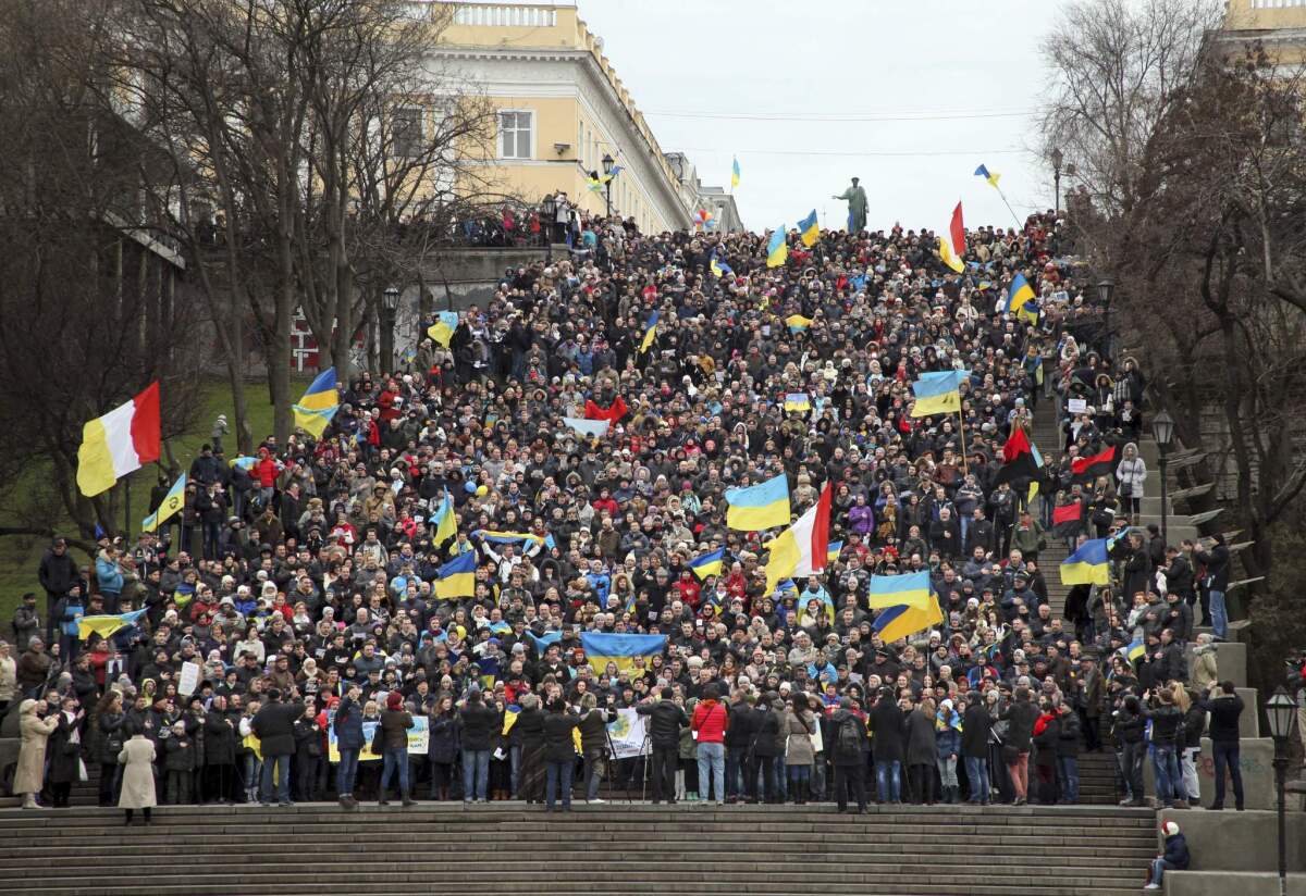 Ukrainians sing the national anthem while waving national flags during an antiwar protest on the historic Potemkin Steps, considered a formal entrance into the city of Odessa from the sea.