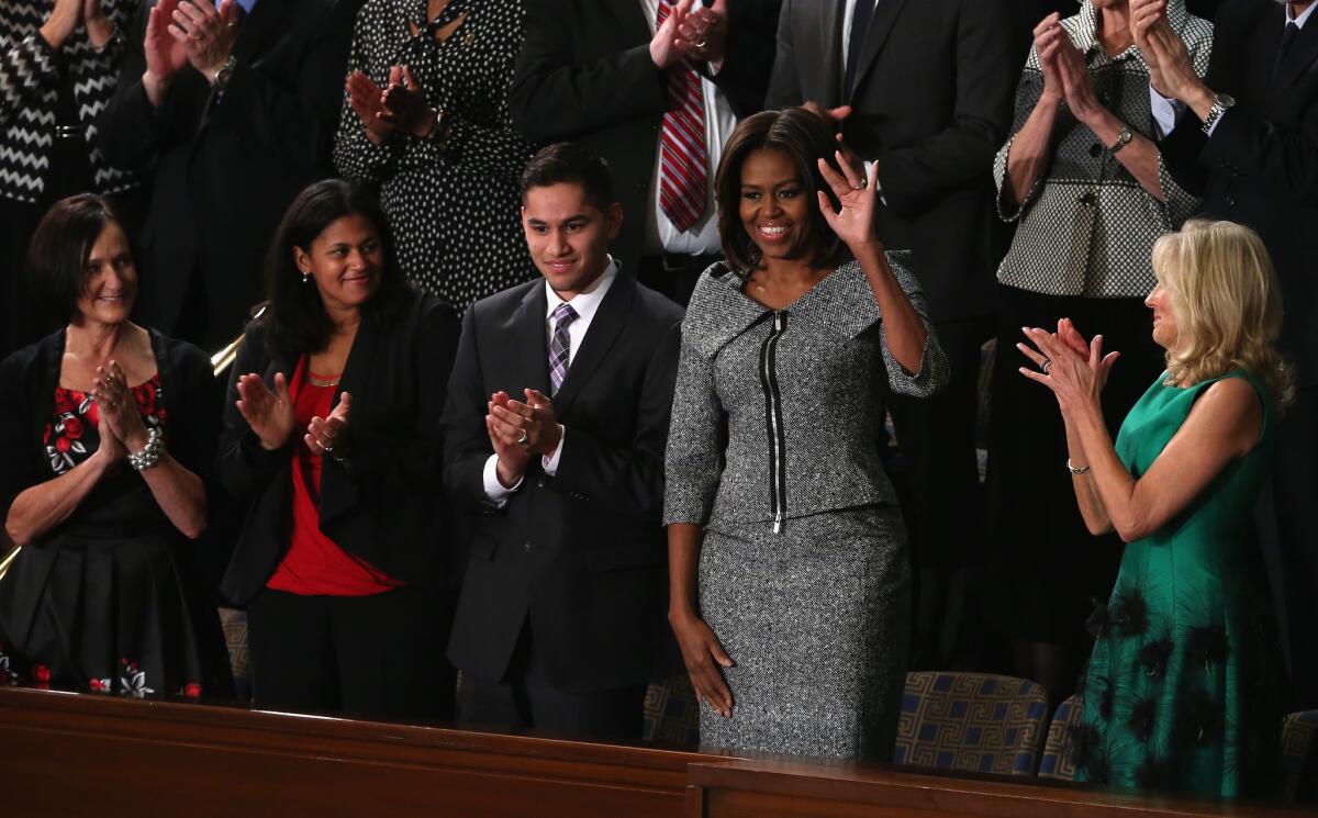 Michelle Obama, wearing a Michael Kors salt-and-pepper tweed suit, waves to the crowd at the State of the Union address on Tuesday night.
