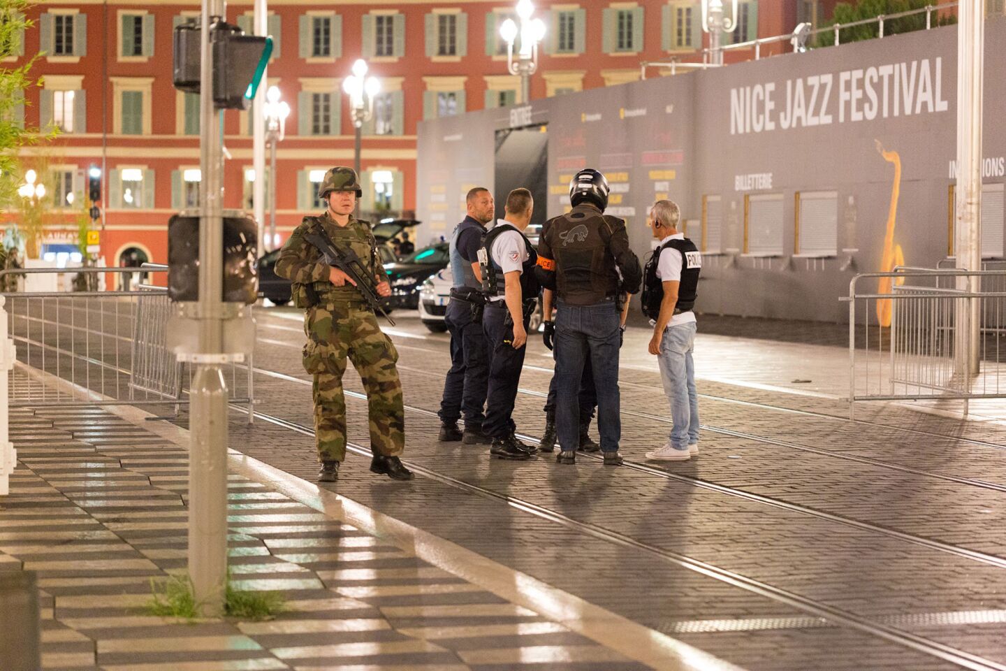 A soldier stands guard alongside police officers near the site of the truck attack.