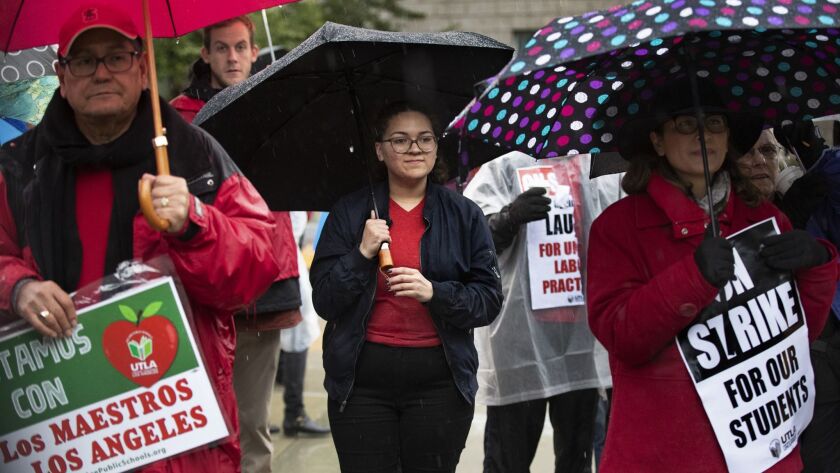 Mia Medina, center, 17, a senior at John F. Kennedy High School in Granada Hills, joins teachers and other students on the picket line outside the school on the first day of the strike.