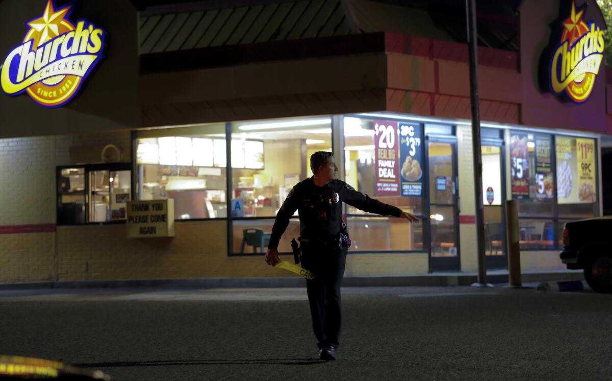A San Diego Police officers sealsoff the area around a Church's Chicken restaurant in Otay Mesa.