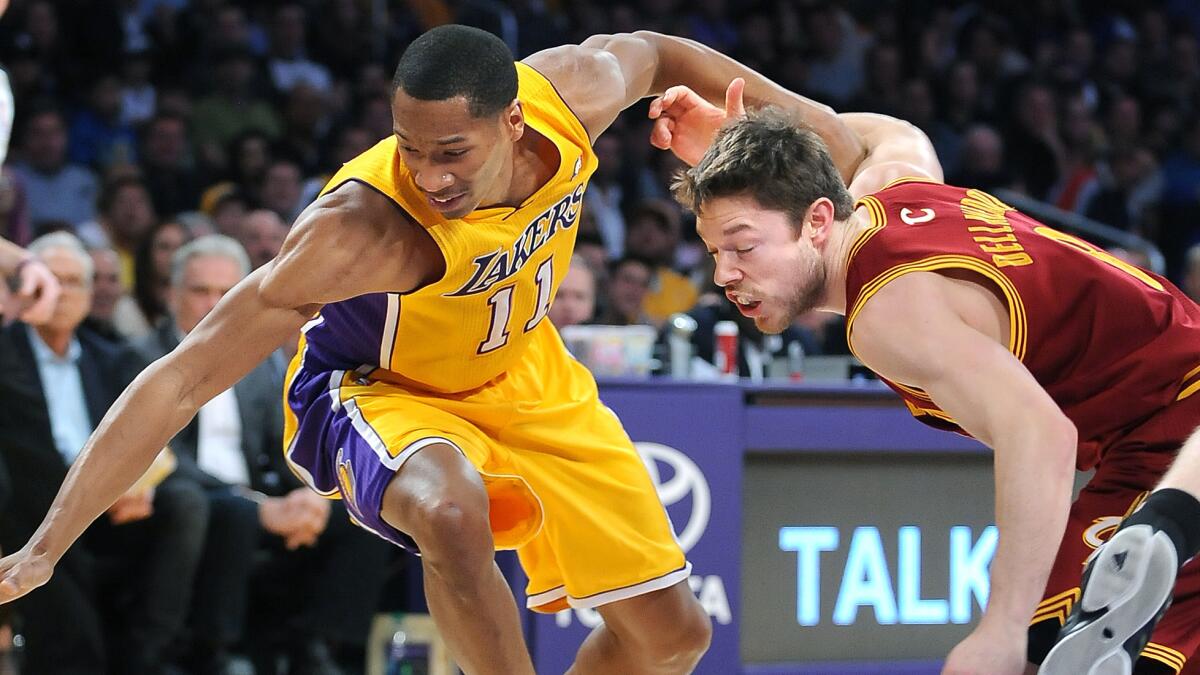 Lakers forward Wesley Johnson, left, and Cleveland Cavaliers guard Matthew Dellavedova chase after a loose ball during a game in January.