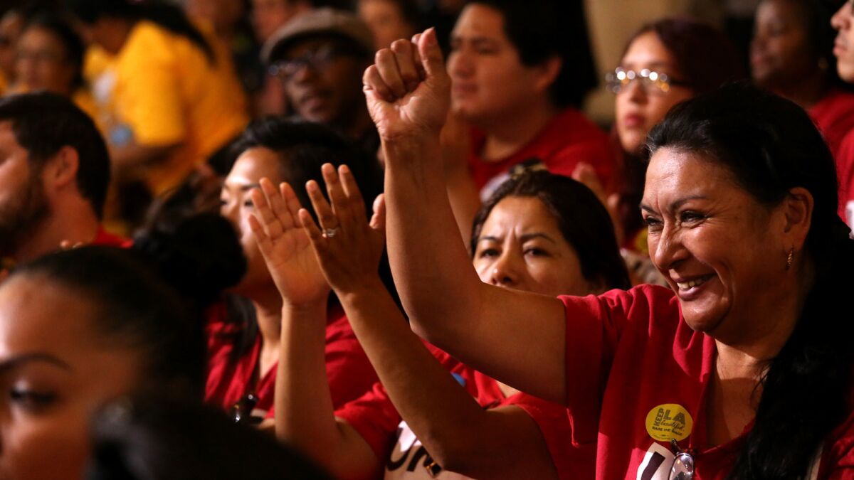 Audience members celebrate at a May 19 meeting where the Los Angeles City Council supported raising the city's minimum wage to $15 per hour.