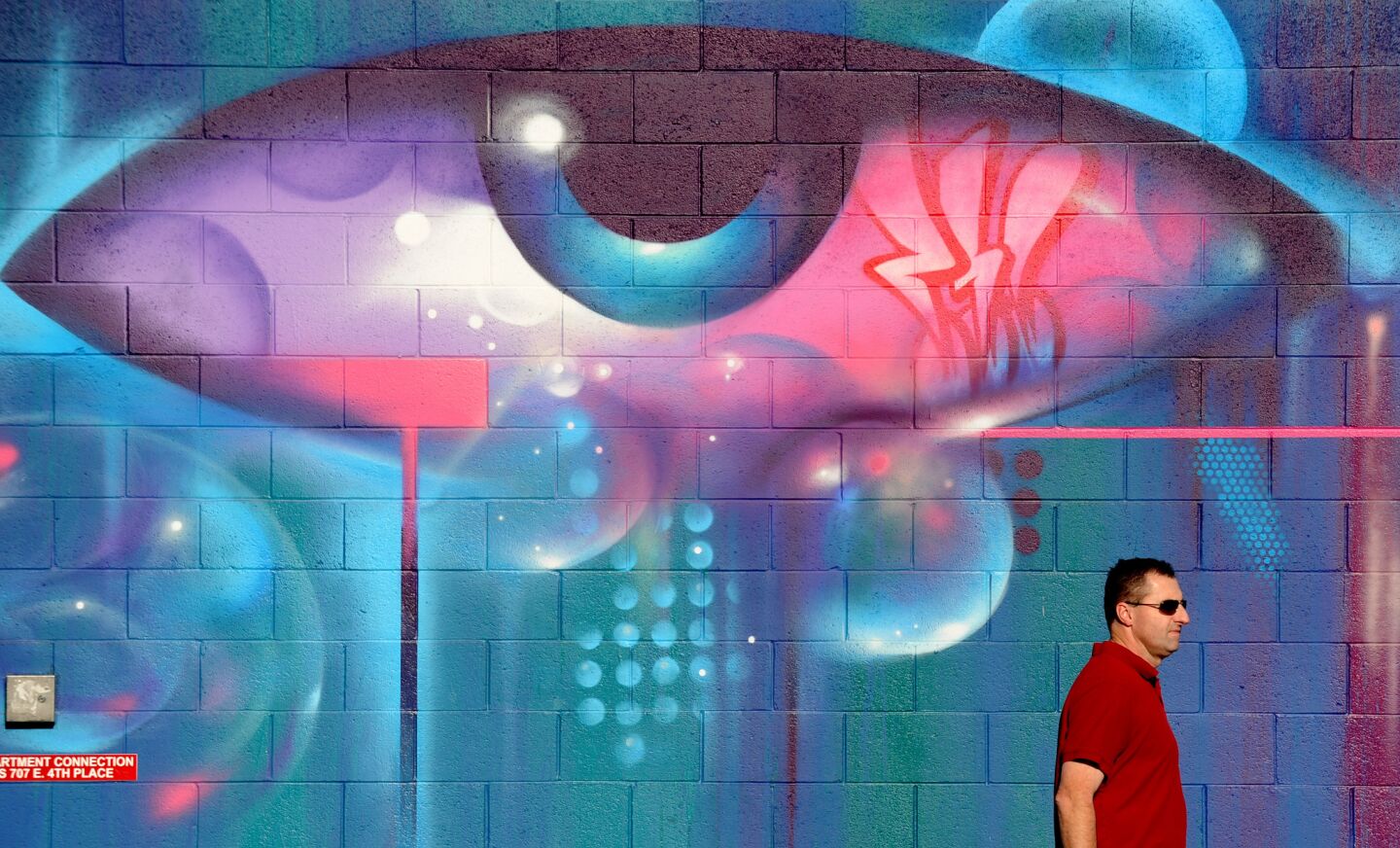 A man walks by a mural along 3rd Street in the Arts District of downtown Los Angeles in January.