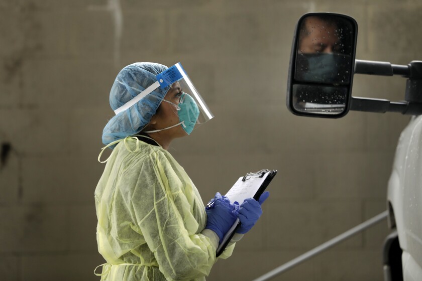 MADERA, CALIFORNIA-APRIL 8, 2020-Dental assistant Maribel Zaragoza volunteered to work on testing for Covid 19 at the Camarena Health Center which is working together with the Madera County Rapid Contact Tracing Team to help identify and isolate people who have tested positive or come into contact with a coronavirus carrier. On March 8, 2020, Zaragoza ask questions of a man requesting to be tested for coronavirus. The Madera County Rapid Contact Tracing Team is a model program to identify anyone who has come into contact with a person who tests positive for Covid 19 coronavirus. They identify those who need to go into home quarantine and possibly house them at a hotel if needed. (Carolyn Cole/Los Angeles Times)