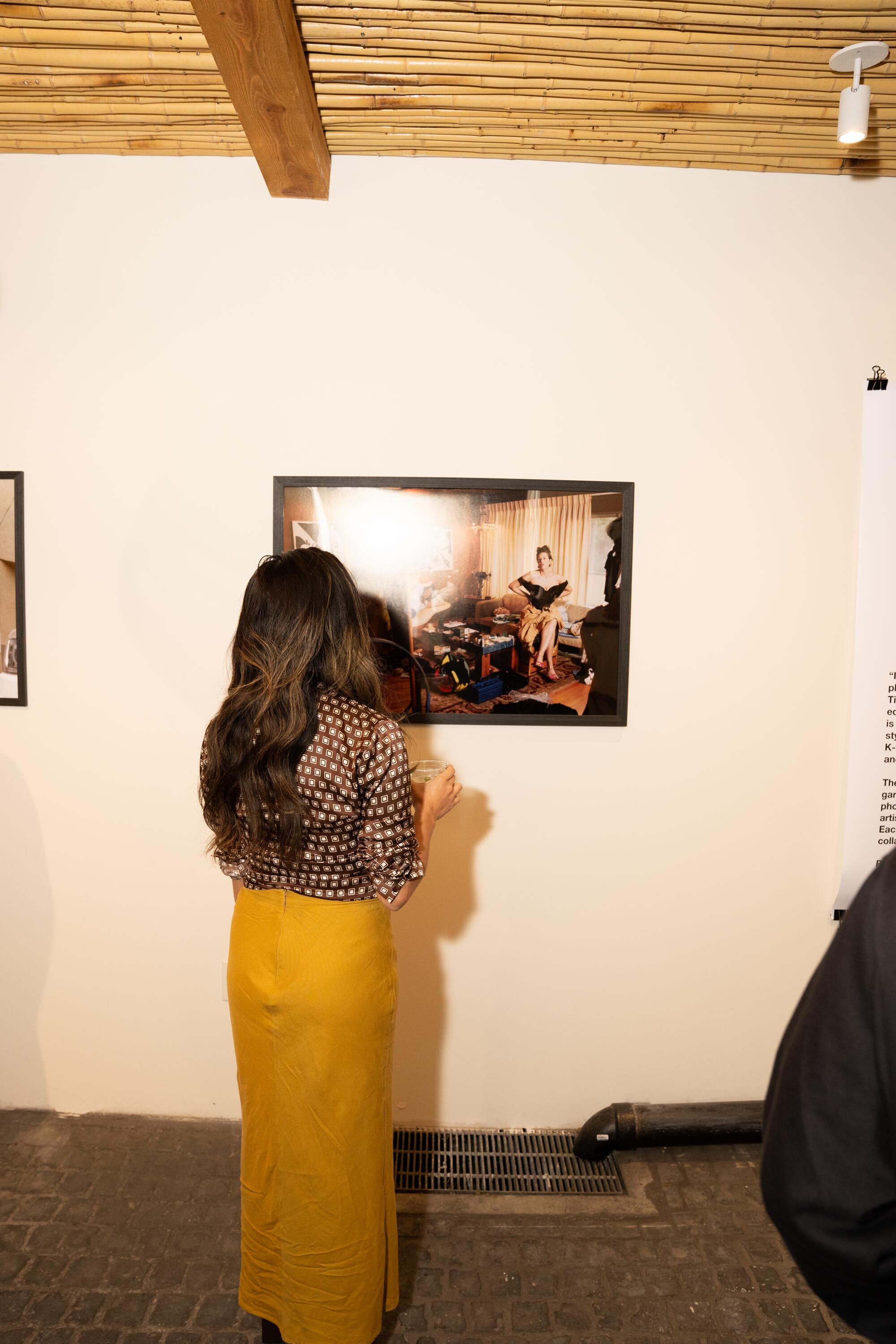 A guest views a photograph by Cody Critcheloe of costume designer Natasha Newman-Thomas.