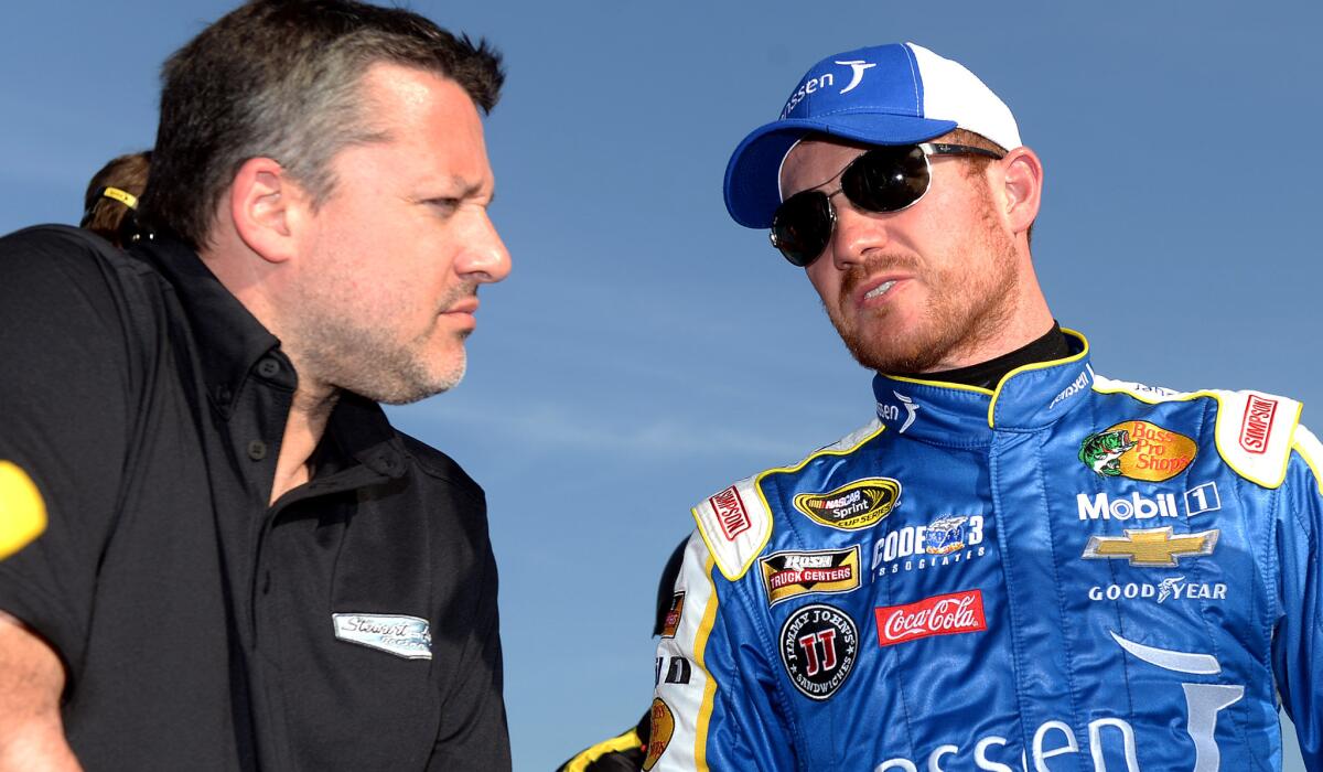 NASCAR driver Brian Vickers, right, speaks with car owner Tony Stewart after qualifying Friday at Auto Club Speedway.