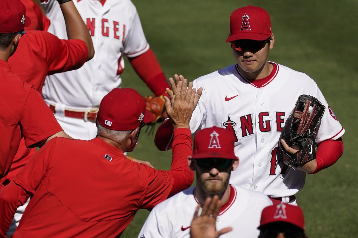 Shohei Ohtani celebrates with coaches and teammates after the Angels' 6-5 win Sunday.