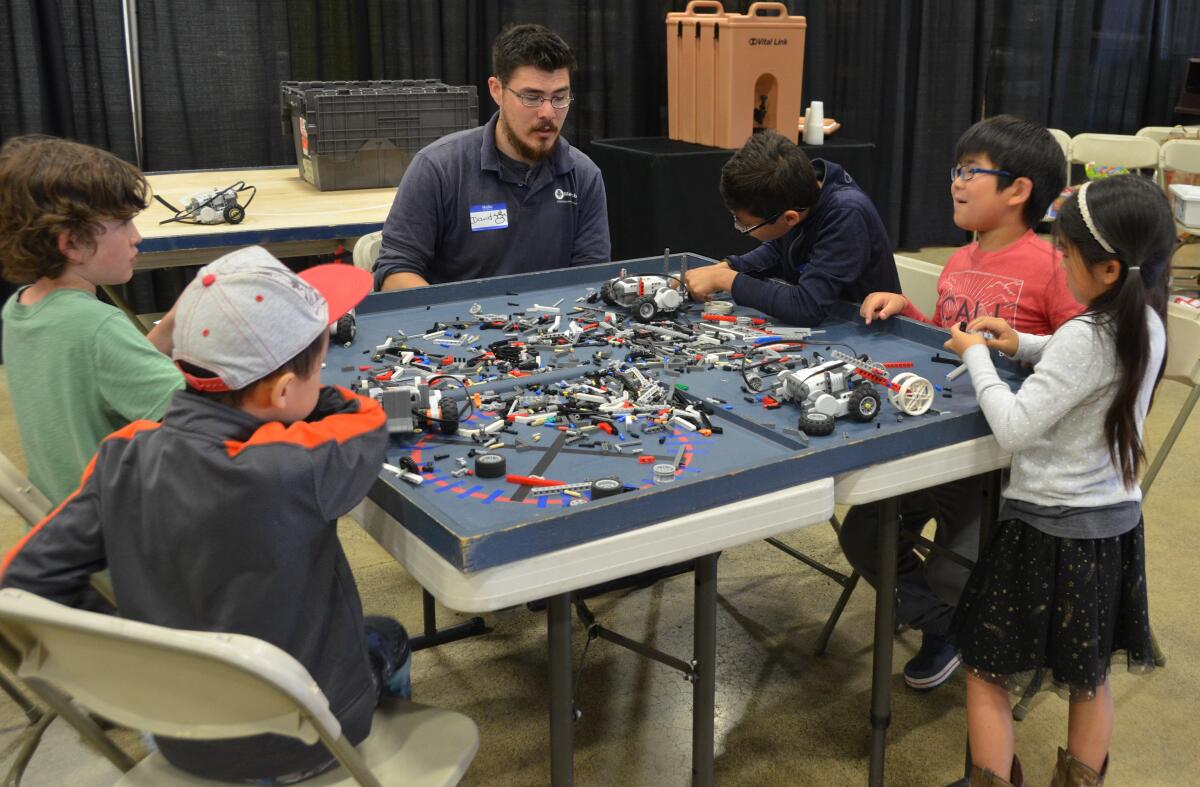 Kids build robots using Legos from the Lego Mind Store as part of the "Mathobotix" booth during the Imaginology event.