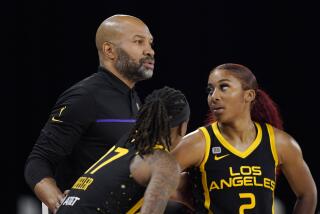 Los Angeles Sparks head coach Derek Fisher, left, talks with guard Erica Wheeler, center, and guard Te'a Cooper during the second half of a WNBA basketball game against the Las Vegas Aces Friday, July 2, 2021, in Los Angeles. The Aces won 66-58. (AP Photo/Mark J. Terrill)