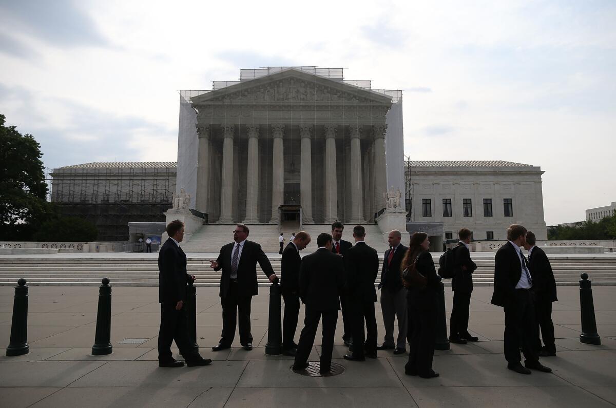 People stand in front of the Supreme Court in Washington.