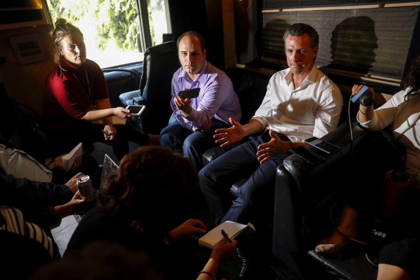 Democratic candidate for governor Gavin Newsom speaks to reporters on his campaign bus after departing San Francisco for a weeklong tour.