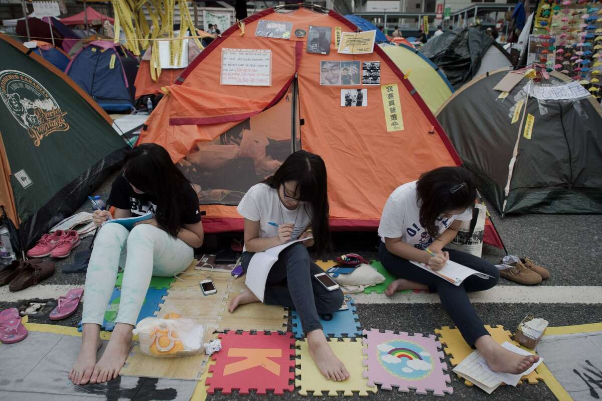 Pro-democracy protesters sit and study outside their tents in the Admiralty district of Hong Kong on Nov. 2.