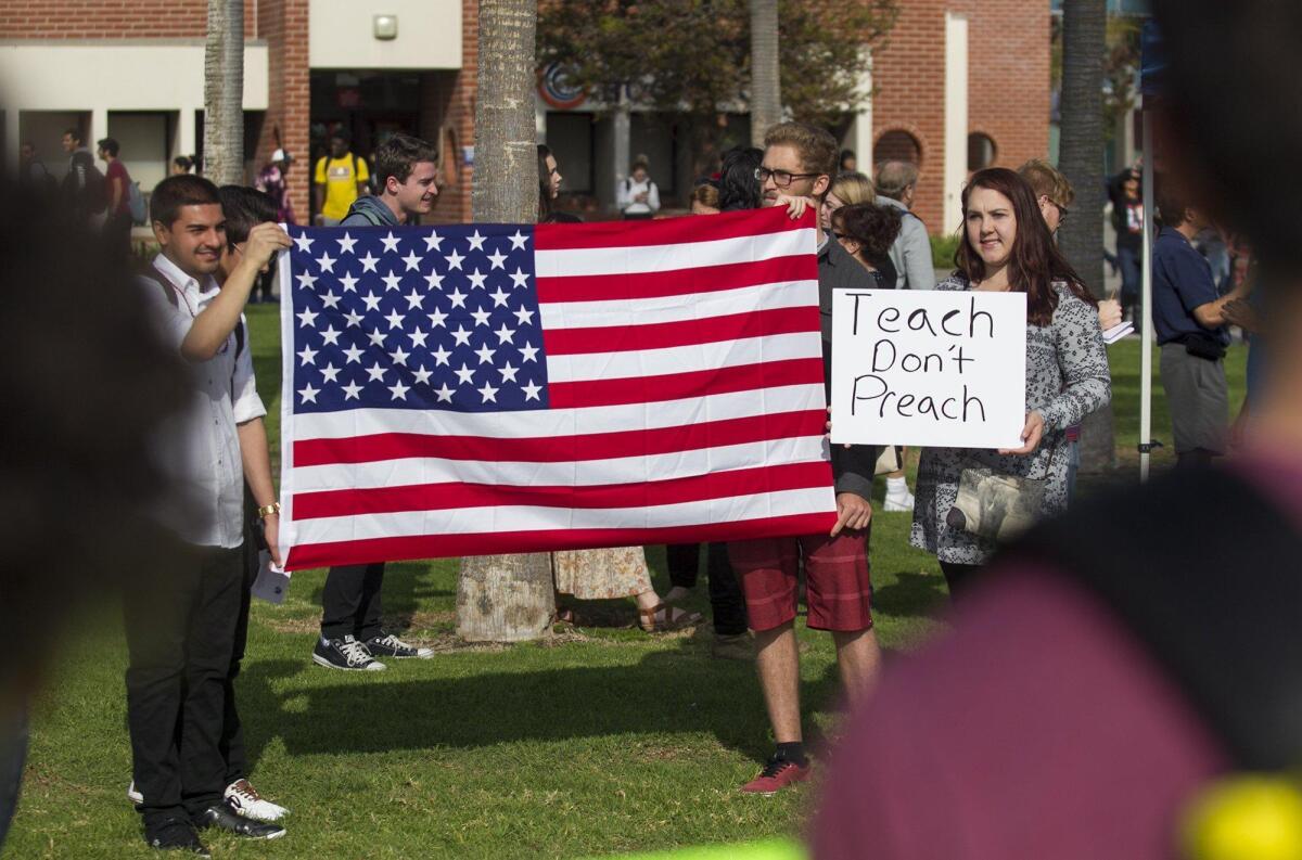 Members of the Republican Club at Orange Coast College including Brittany Perrigo, right, hold a counter-protest Dec. 12 at a rally that was in support of OCC Professor Olga Perez Stable Cox who was video-recorded speaking out against President Trump in class.