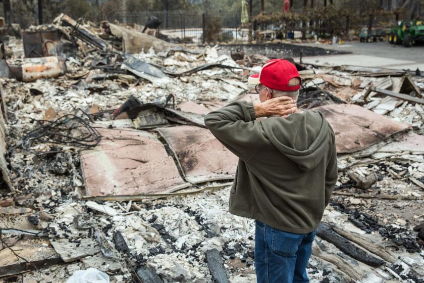 Jay Albertson takes a moment as he views his burned down home of 30 years after it was destroyed by the Valley Fire in 2015. Areas of wine country that were devastated by wildfire now have some of the lowest poverty rates in the U.S., new census data show.