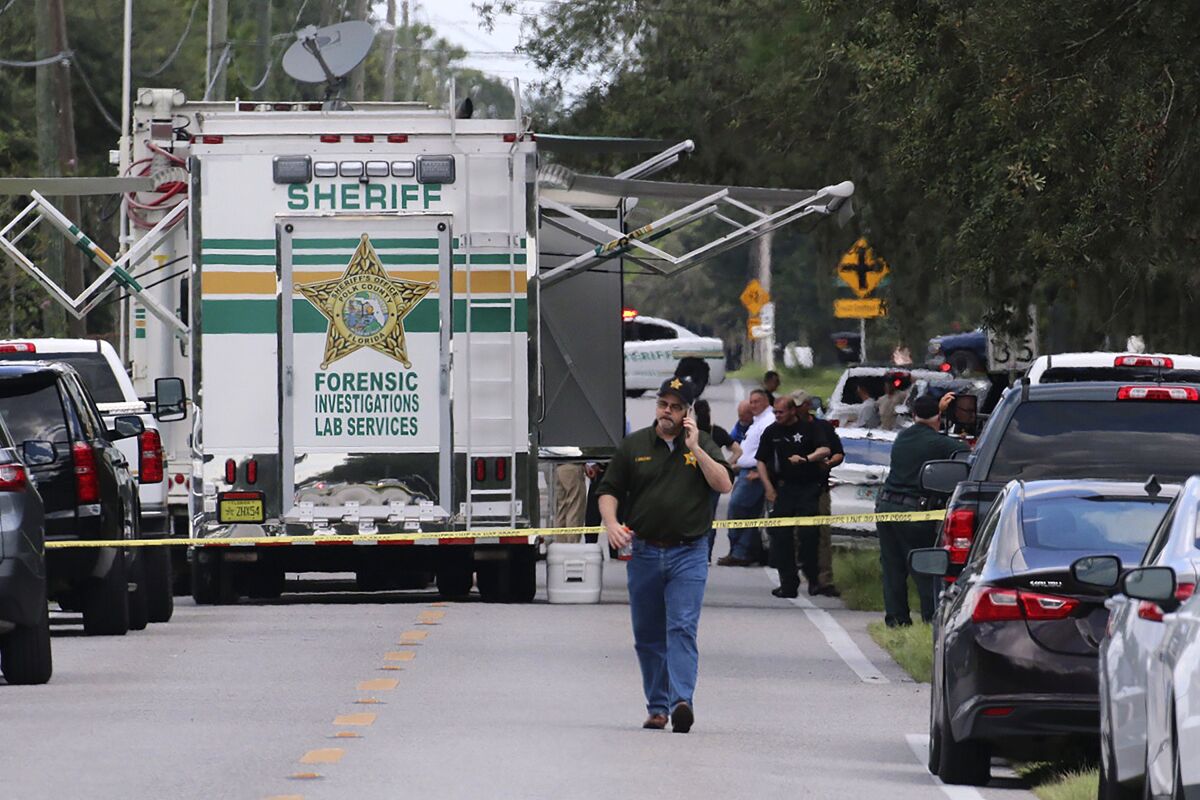 Polk County, Fla., Sheriff's officials work the scene of a multiple fatality shooting Sunday, Sept. 5, 2021, in Lakeland, Fla. Four people are dead including a mother who was still cradling her now deceased baby in what Florida sheriff's deputies are calling a massive gun battle with a suspect. (Michael Wilson/The Ledger via AP)
